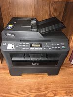 Full view of Brother MFC-7860DW multifunction printer showing automatic document feeder, output tray, and front control panel.