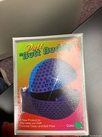 Front view of boxed Putt Butt Buddy golf accessory in blue color showing golf ball shape with holes.
