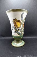 Front view of Gouda pottery vase showing yellow tulip flowers and green base.