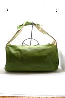 Front view of the bag showing Kelly green leather and attached handle with visible wear on the leather.