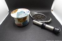 Photo showing ceramic French butter dish with floral pattern and stainless steel apple slicer behind it.
