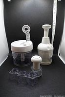 Two manual food processors with clear containers and white tops, blade attachments visible in front, included for cutting and chopping fruits and cheeses