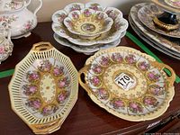 Overview of two handled serving dishes and stack of three scalloped bowls