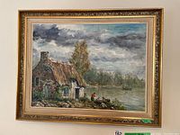 Full view of framed oil painting depicting lakeside cottage and figures
