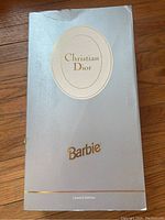 Original silver-grey box featuring gold Christian Dior logo and Barbie logo, marked Limited Edition. Box has minor wear and tear.