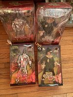 All four Wizard of Oz Barbie dolls in original packaging, two shrink-wrapped, two visible with Tin Man and Scarecrow figures.