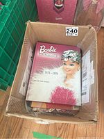 Cardboard box containing Barbie Fashion hardcover and various magazines