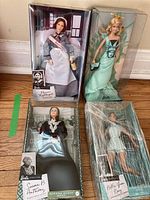 Four Barbie dolls in original packaging, displayed upright on floor for condition and identification.