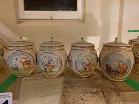 Four vintage Winnie the Pooh honey pot ceramic music boxes arranged in a row with certificates beneath.