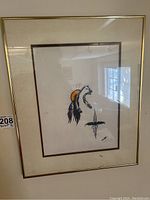 Photo of framed print artwork titled 'The Believer' showing Indigenous motifs including a bear and feathers with sun in background. Artwork signed by Randy Knott 1982.