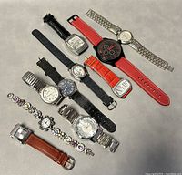 Top-down image showing all ten assorted vintage watches arranged on a flat surface with various band types and watch face shapes.