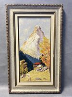 Full view of framed painting showing mountain, cabin, trees, and path