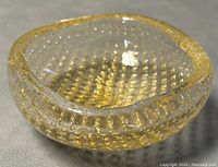Front angle view showing the bowl's rounded square shape, clear glass, and gold fleck pattern.