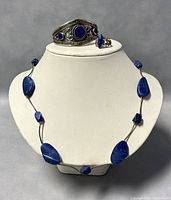 Front view of lapis lazuli necklace, bangle, and ring displayed on a bust.
