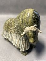 Front-right view of green mottled soapstone yak sculpture showing polished head and carved fringe detail