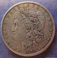 Obverse side of the 1879 Morgan silver dollar coin showing Lady Liberty's head and the date.