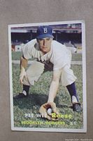 Front of 1957 Topps Pee Wee Reese card showing player in Brooklyn Dodgers uniform crouching on grass field.