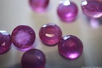 Close-up of multiple round cut pink rubies showing clarity and color.