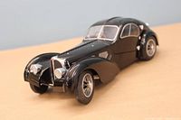 Front and side view of black Bugatti Type 57 die-cast model showing detailed grille, headlamps, and front fender design.