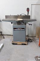 Front view of Delta 6" jointer on mobile base, showing infeed and outfeed tables and fence.