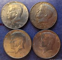 Obverse sides of four 1968 Kennedy silver half dollars showing left-profile bust of John F. Kennedy, date 1968, inscriptions.