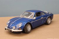 Front angled view showing the blue metallic finish, headlights, front grille, and license plate.