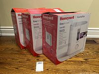 Set of three original Honeywell humidifier boxes stacked together showing branding and product information.