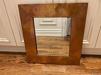 Front view of the square mirror with copper frame showing the full reflective surface and frame texture.