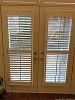 Pair of patio door shutters installed, showing front view with slats open.