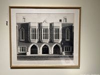 Frontal view of the framed black and white vintage photograph showing a school building with multiple arched entrances and tall windows.