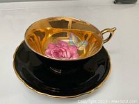 Cup and saucer front-on view showing gilt interior and pink cabbage rose