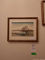 Framed print hanging on wall showing full image in bamboo-style frame at slight angle