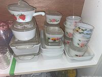 Overall lot on shelf showing milk glass casserole dishes, square bowls, fluted bowls and clear glass soup bowls