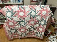 Full view of quilt draped over furniture showing overall geometric pattern