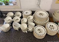 Overview of stacked plates, bowls, cups showing full lot