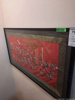 Angled view of framed silk embroidery artwork hung on wall