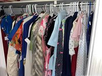 Rack of assorted vintage women's dresses in various colors, prints and styles