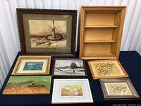 Overall view of all 8 pieces of art and one wooden shelf on a blue cloth background.