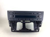 Front view of BMW Professional car radio unit showing the display screen, control buttons, and mounting frame.