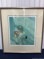 Front view of the framed art showing the image of a girl holding a Raggedy Ann doll, with visible signature on the lower right corner.