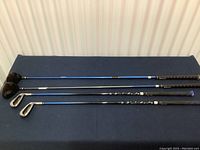 Four King Cobra right handed golf clubs laid side by side, showing shafts and grip ends