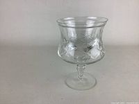 Front angle view of one crystal shrimp cocktail glass showing cross and olive cut pattern and flared rim.