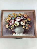 Frontal view of the framed floral still life painting showing overall condition and signature.