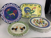 Decorative chicken themed dishes showing large round, rectangular, lattice edged, and lidded dishes with rooster artwork