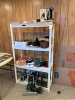 Shelf unit with multiple metal bookends, storage bins, envelopes, folders, and miscellaneous office supplies