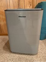 Front view of Hisense dehumidifier showing brand logo and overall design in light gray and dark gray.