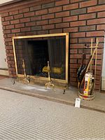 Full view of fireplace screen, andirons, and tools on stand next to fireplace showing discoloration and set placement