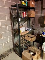 Metal shelving unit against basement wall with five shelves. Various storage boxes and cans are on shelves but not included.