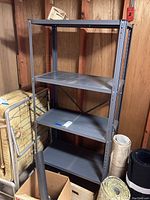 Front and side perspective showing the complete metal shelving unit in a basement setting with surrounding items.