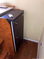 Side view of Kenmore mini fridge with woodgrain finish and vertical handle.
